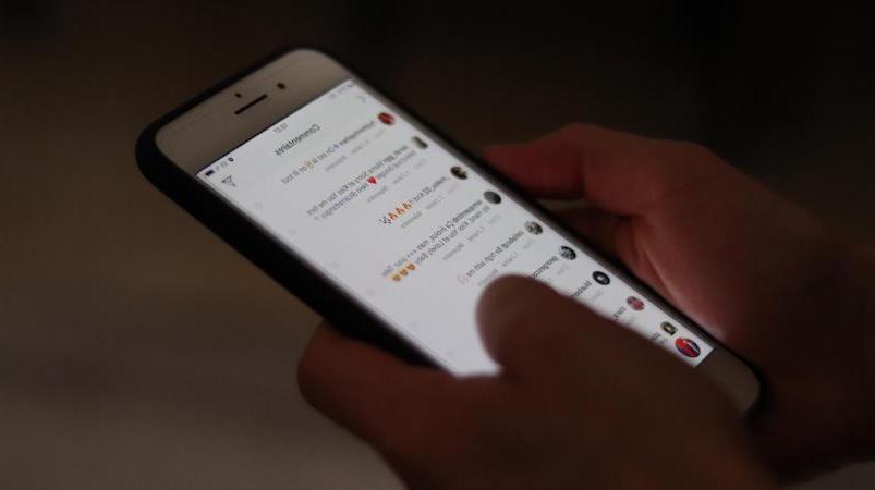 موبایل در دست کاربر با صفحه روشن